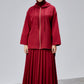 Woman wearing a red outfit with a matching hijab on a gray background