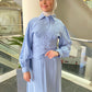 Woman wearing a light blue abaya in an indoor setting