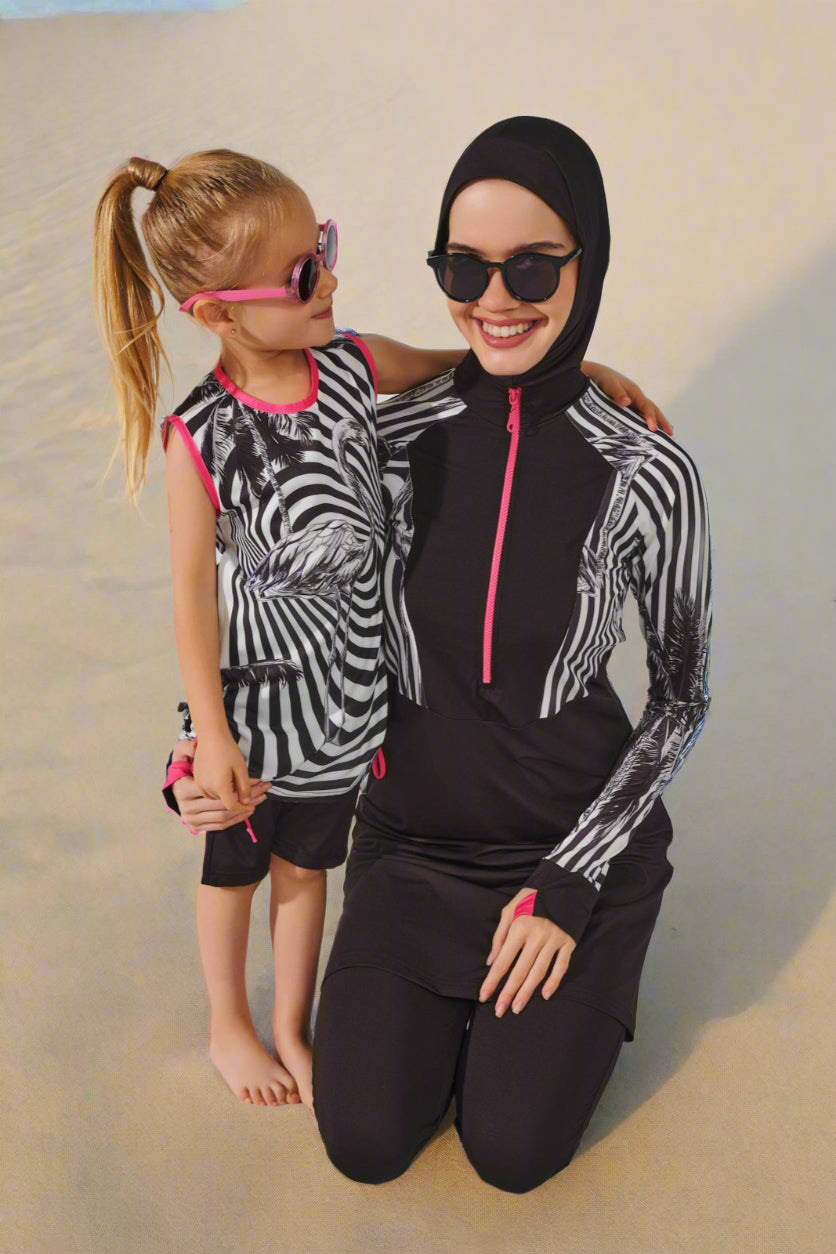 Woman and child wearing matching zebra print outfits with black hijabs on a white background