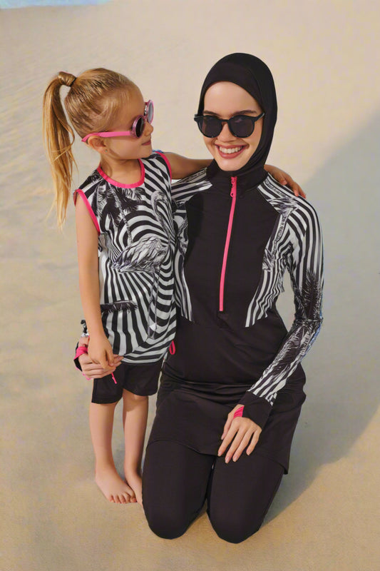 Woman and child wearing matching zebra print outfits with black hijabs on a white background