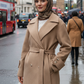 Woman in a beige coat and hijab standing on a city street with Big Ben in the background