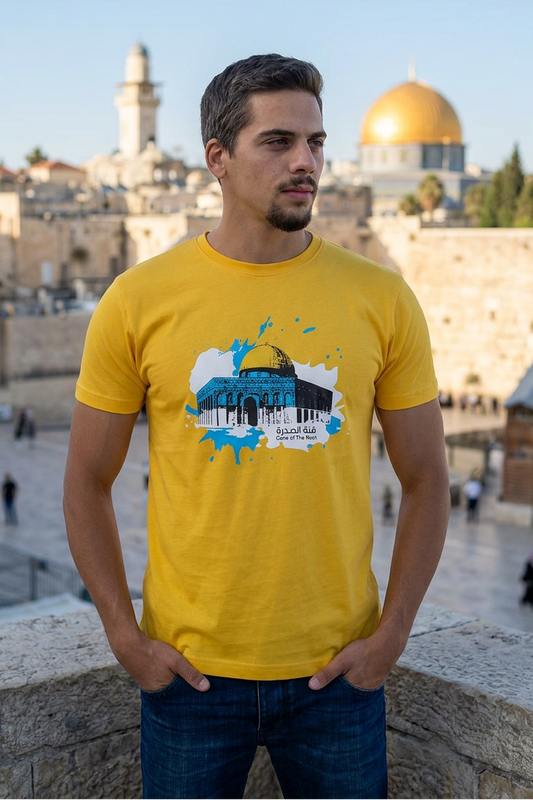 Man wearing a yellow t-shirt with a graphic design in front of a cityscape