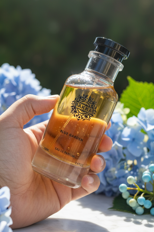 Hand holding a small bottle of Kiehl's product with blue flowers in the background