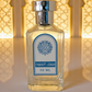 Bottle of Bakka perfume with a blue label against a decorative wall background