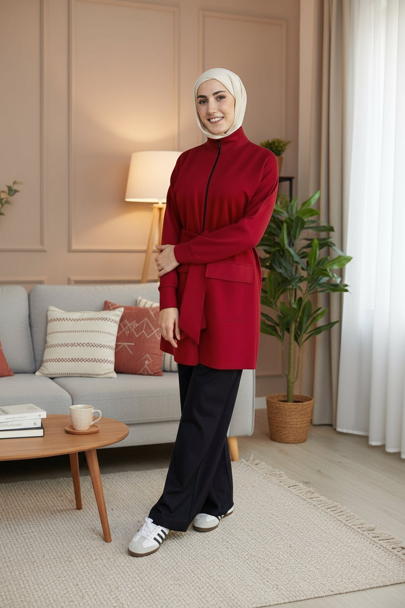 Person wearing a red outfit standing in front of a gray door.