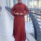 Person wearing a red outfit standing on a modern architectural background