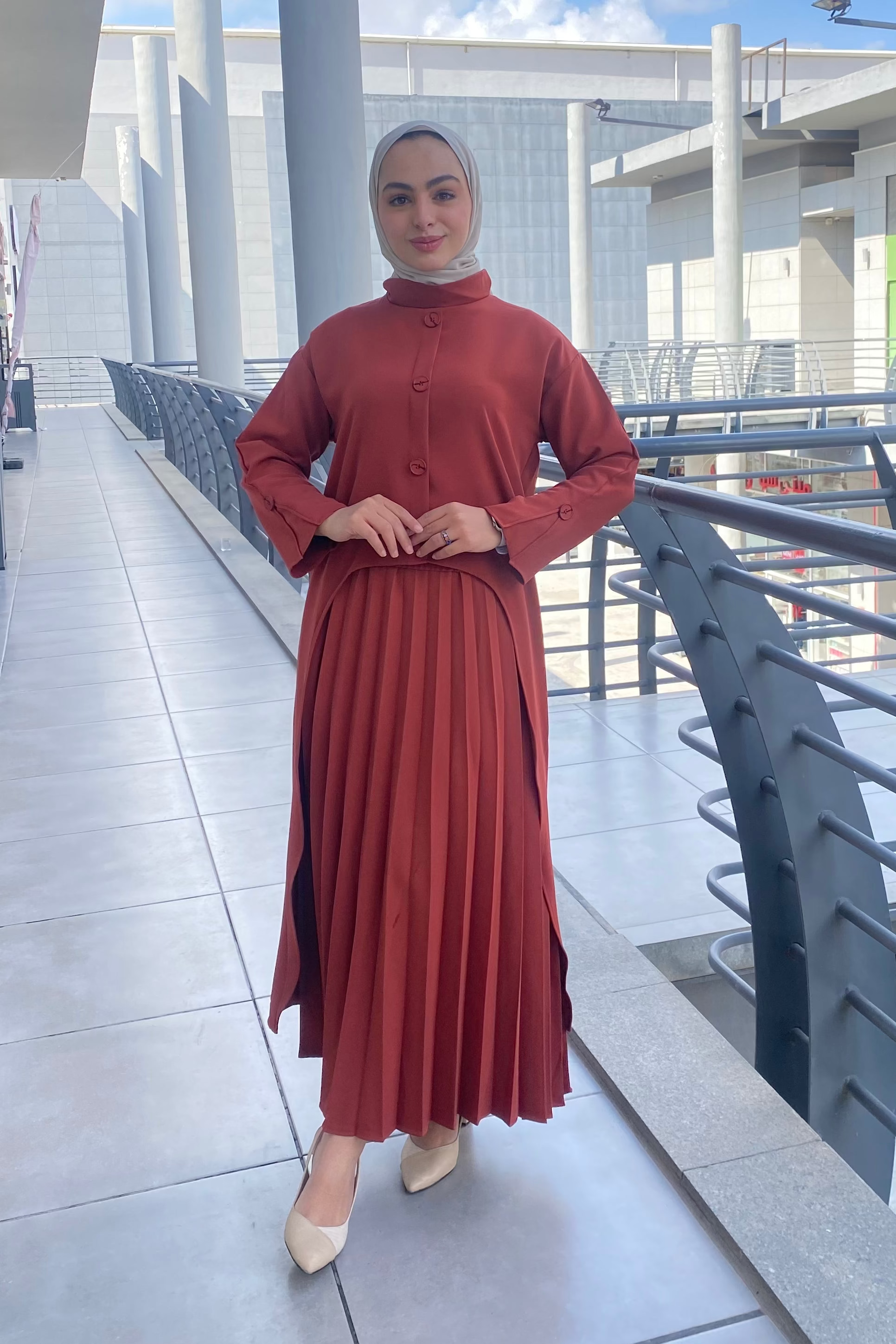 Person wearing a red outfit standing on a modern architectural background