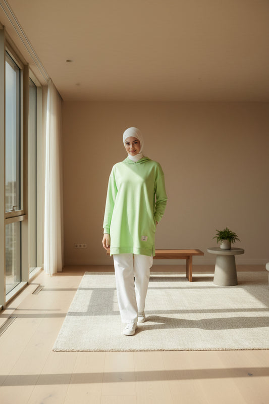A woman wearing a light green casual blouse with long sleeves, suitable for daily use.